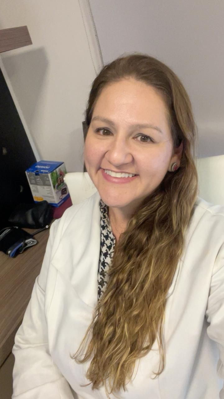 Dra. Raphaela Mannarino, cardiologista, de jaleco branco, em retrato próximo